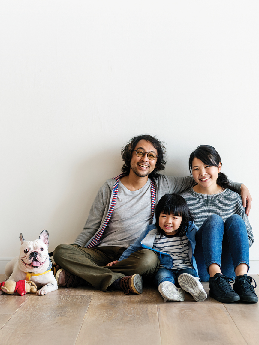 Woman sitting on a hardwood floor with a coffee mug in her hand.